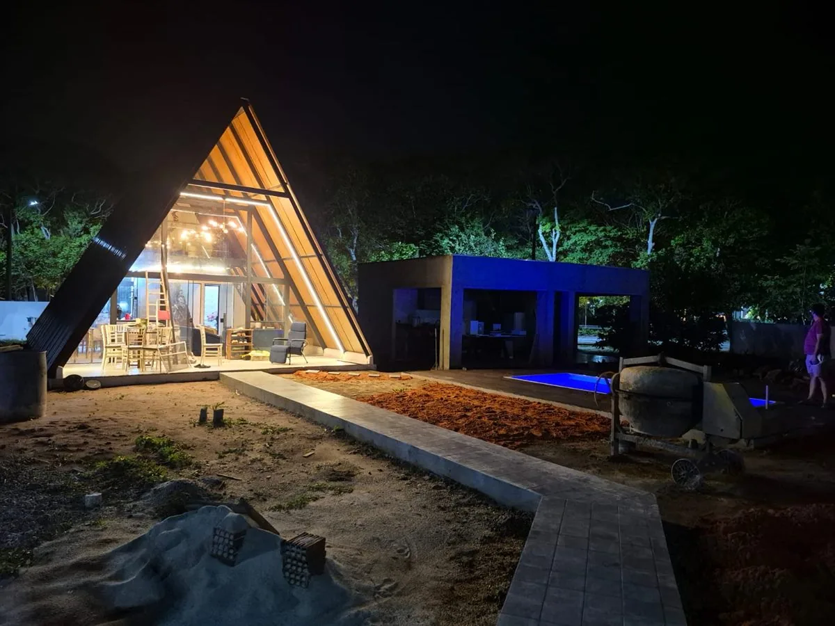 Chalé A-frame iluminado à noite com cobertura termoacústica, obra de alto padrão na Lagoa do Bomfim